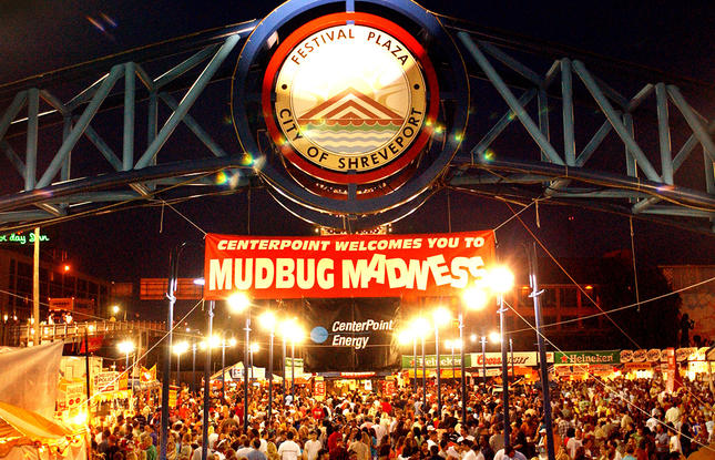 A lively crowd under vibrant lights at the Mudbug Madness Festival in Shreveport, Louisiana.