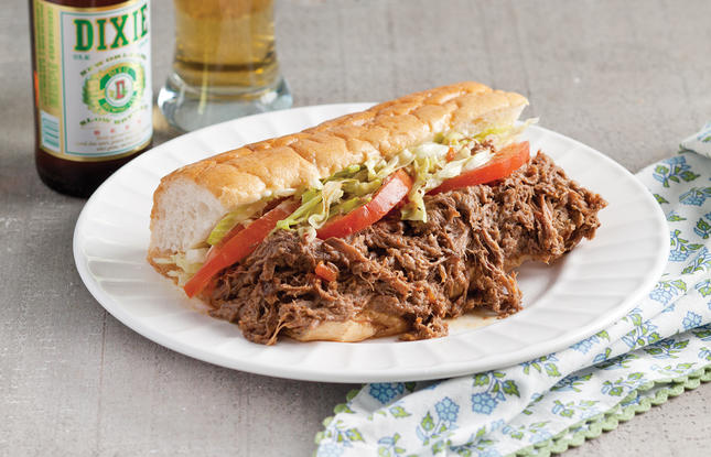 Roast beef po’ boy with debris, topped with lettuce and tomato, served with a Louisiana-made Dixie Beer.