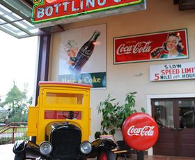 An old-fashioned delivery truck surrounded by vintage Coca-Cola signage at the Biedenharn Museum in Monroe.
