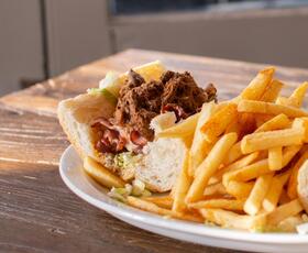 A roast beef po'boy with French fries.