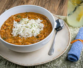 A bowl of Crawfish Etouffe topped with rice.