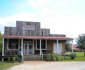 Old cotton gin interior with wooden machinery and baskets of raw cotton.