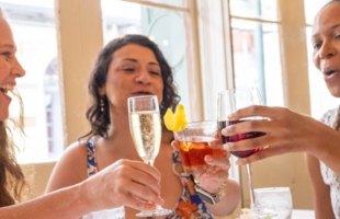 Three women enjoy cocktails in New Orleans.